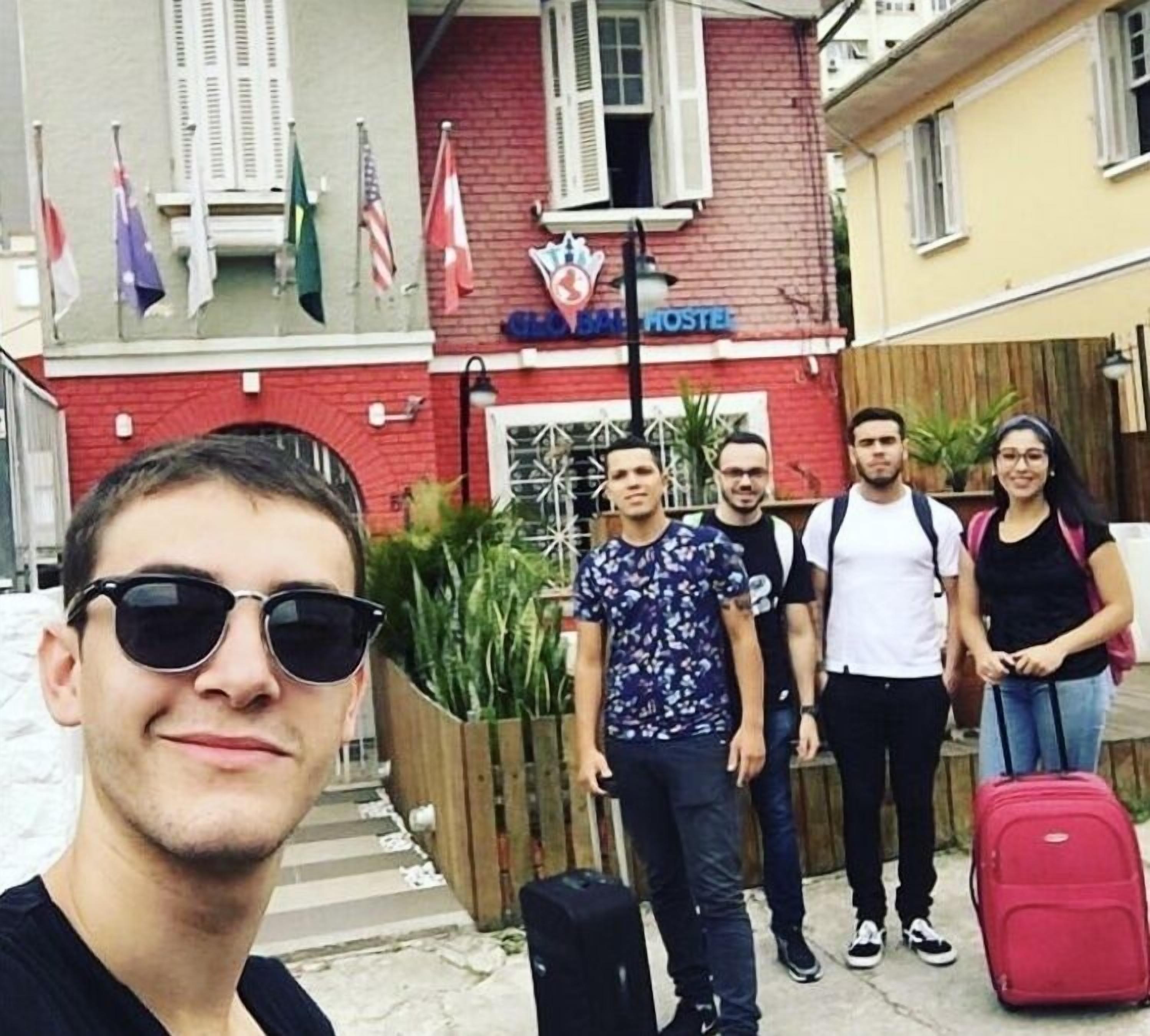Un grupo de personas de pie frente a un edificio con un cartel que dice "BALTIMORE HOSTEL".