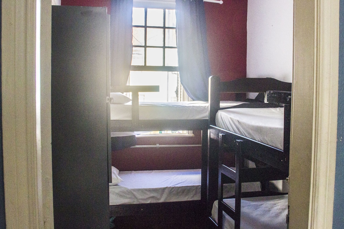 Ein Schlafzimmer mit Etagenbett, Fenster und Vorhängen.