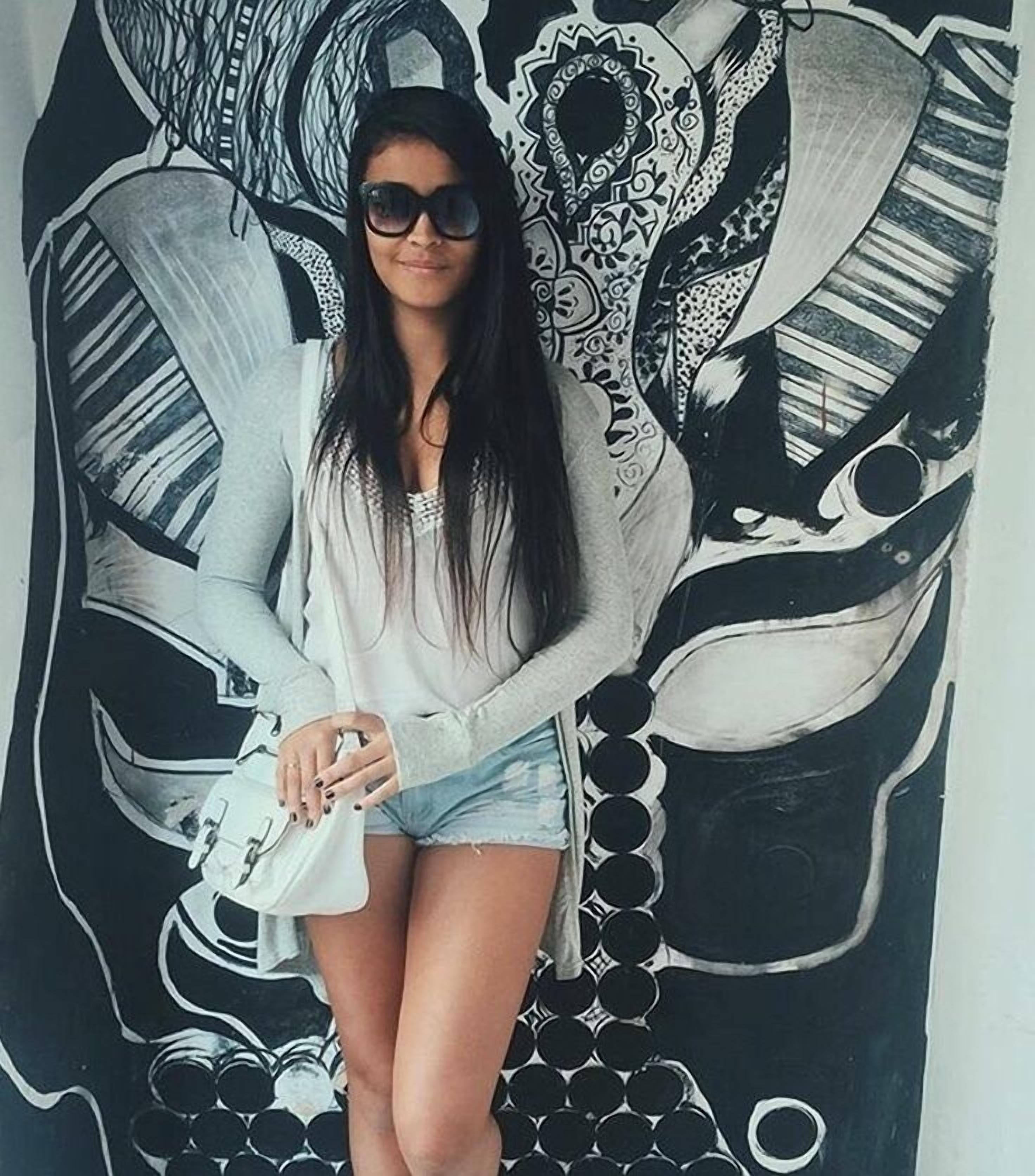 Uma pessoa sentada em frente a um mural grande e detalhado.