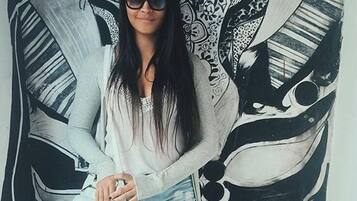 Uma pessoa sentada em frente a um mural grande e detalhado.