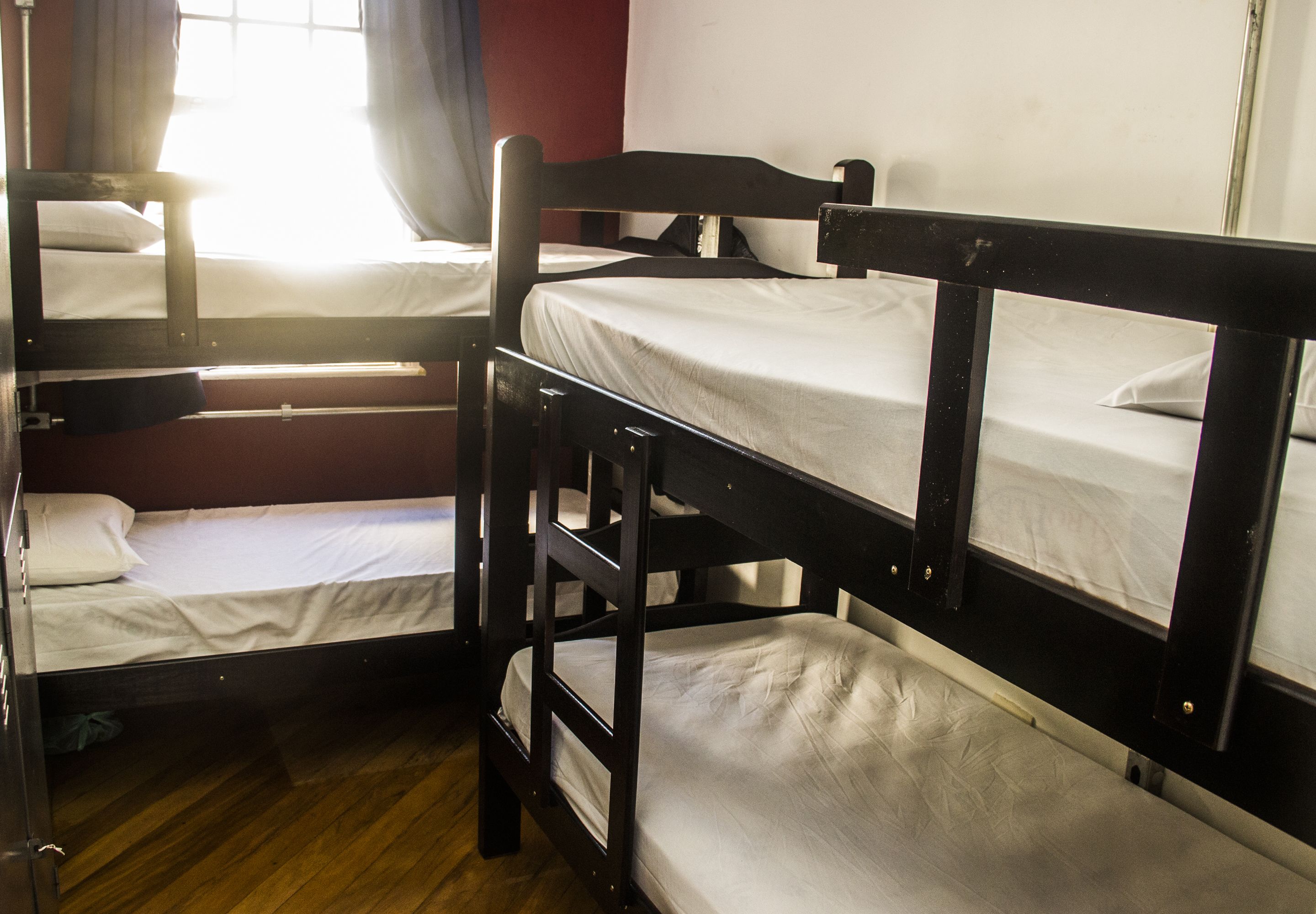 A room with bunk beds and a wooden floor.