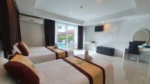 Habitación de hotel con dos camas, un escritorio, una silla, un televisor y vista al exterior.