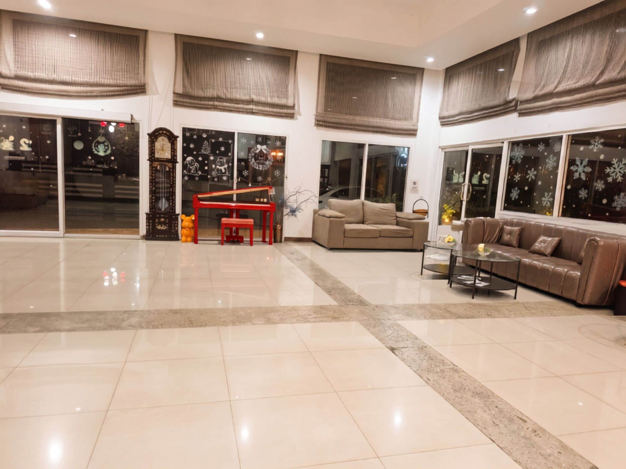 A spacious living area with a piano, sofas, and a coffee table.
