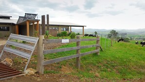A rural property with a wooden fence, a sign reading "The Ridge," and cows grazing in the background. - The Ridge - Gloucester (Gloucester)