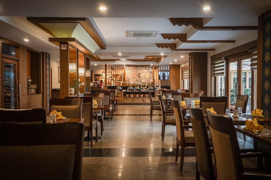 Un restaurante con barra central, varias mesas y sillas.