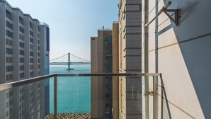 Een hoog gebouw met uitzicht op een brug en water.