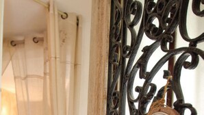 Une chambre avec un lit à baldaquin, une porte en bois ornée d’un portail en métal et une pancarte sur laquelle on peut lire « Chambre ».
