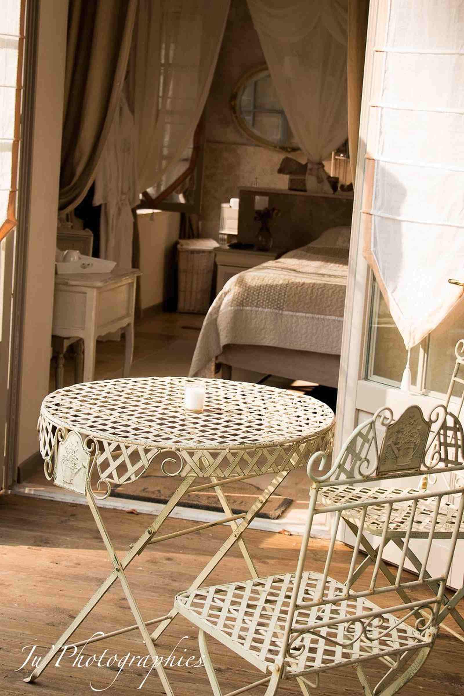 Una habitación con una cama, una mesa redonda y una silla.