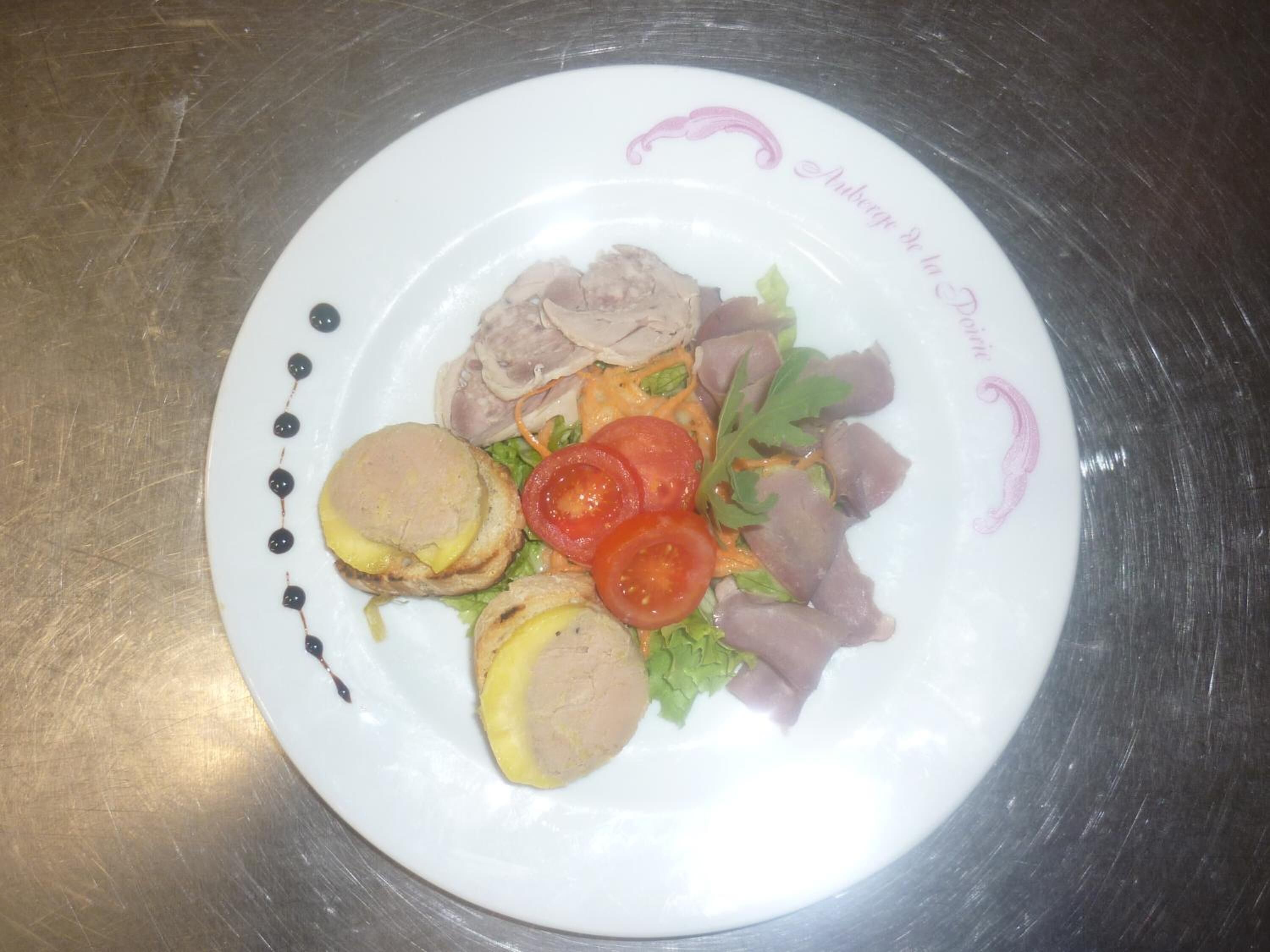 Une assiette garnie de viande en tranches, de fromage et de légumes.