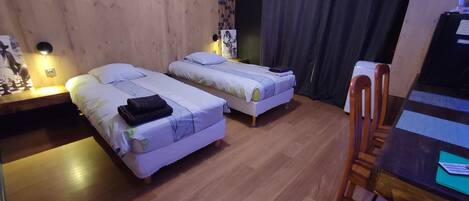 A room with two beds, a desk, and a chair.