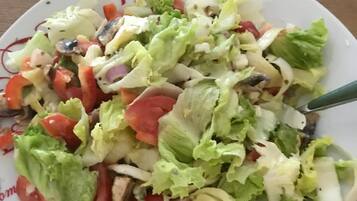 A plate of mixed salad with various vegetables and a spoon.