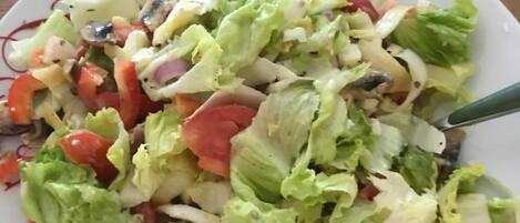 A plate of mixed salad with various vegetables and a spoon.
