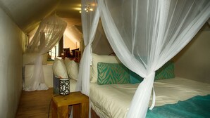 Un dormitorio con cama con dosel, una mesita de noche y una silla.