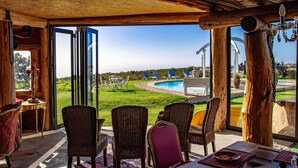 An open patio with wicker furniture, a pool, and a view of the landscape. - T'Niqua Stable Inn (Plettenberg Bay)