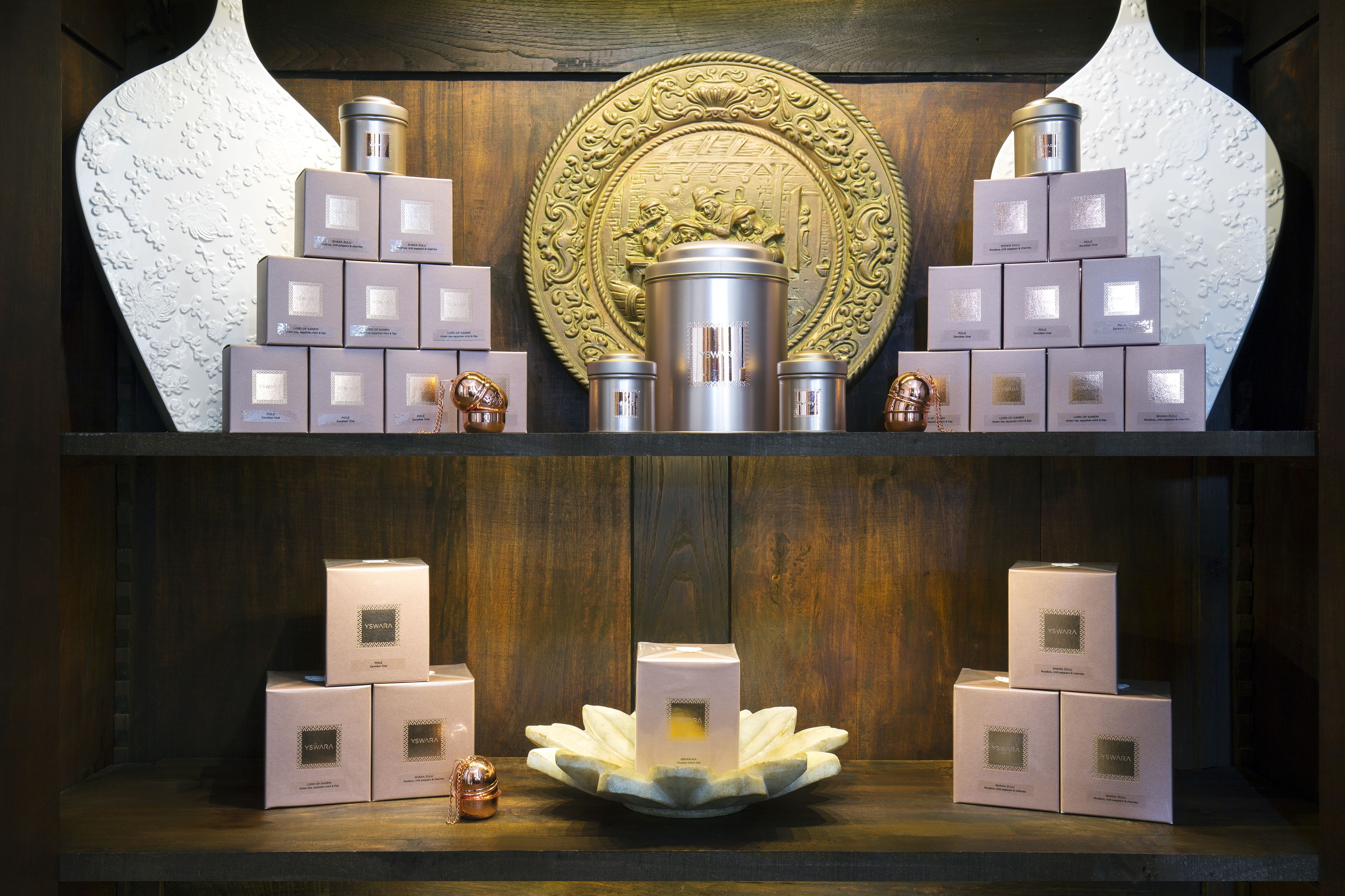 A display of gift boxes and a decorative plate on shelves.