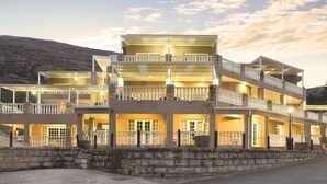 Un hôtel à plusieurs étages, doté de balcons, d’une façade en pierre et d’une enseigne indiquant qu’il s’agit d’un centre de conférences.