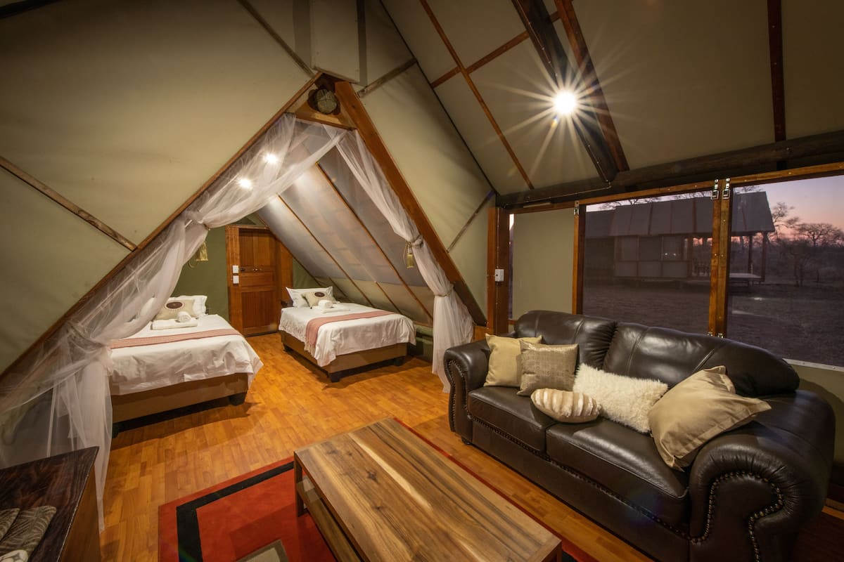 Una habitación acogedora con una cama, un sofá y una mesa de madera.