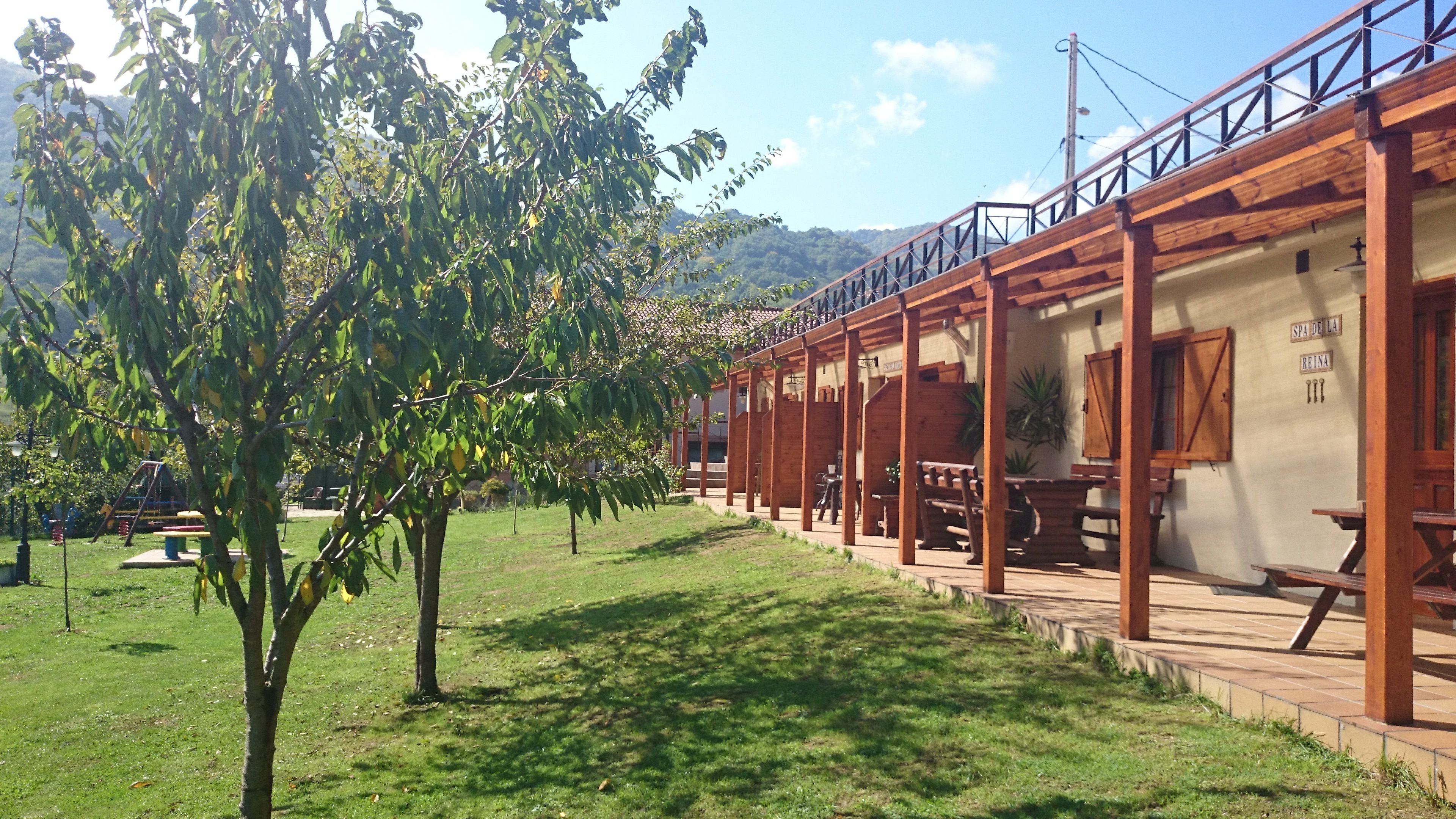 Un edificio de madera con mesas al aire libre y un letrero que dice "SPA DE LA REINA".