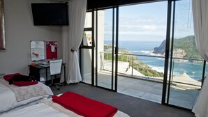 A hotel room with a large window offering a view of the ocean and cliffs. - The Mount Knysna (Knysna)