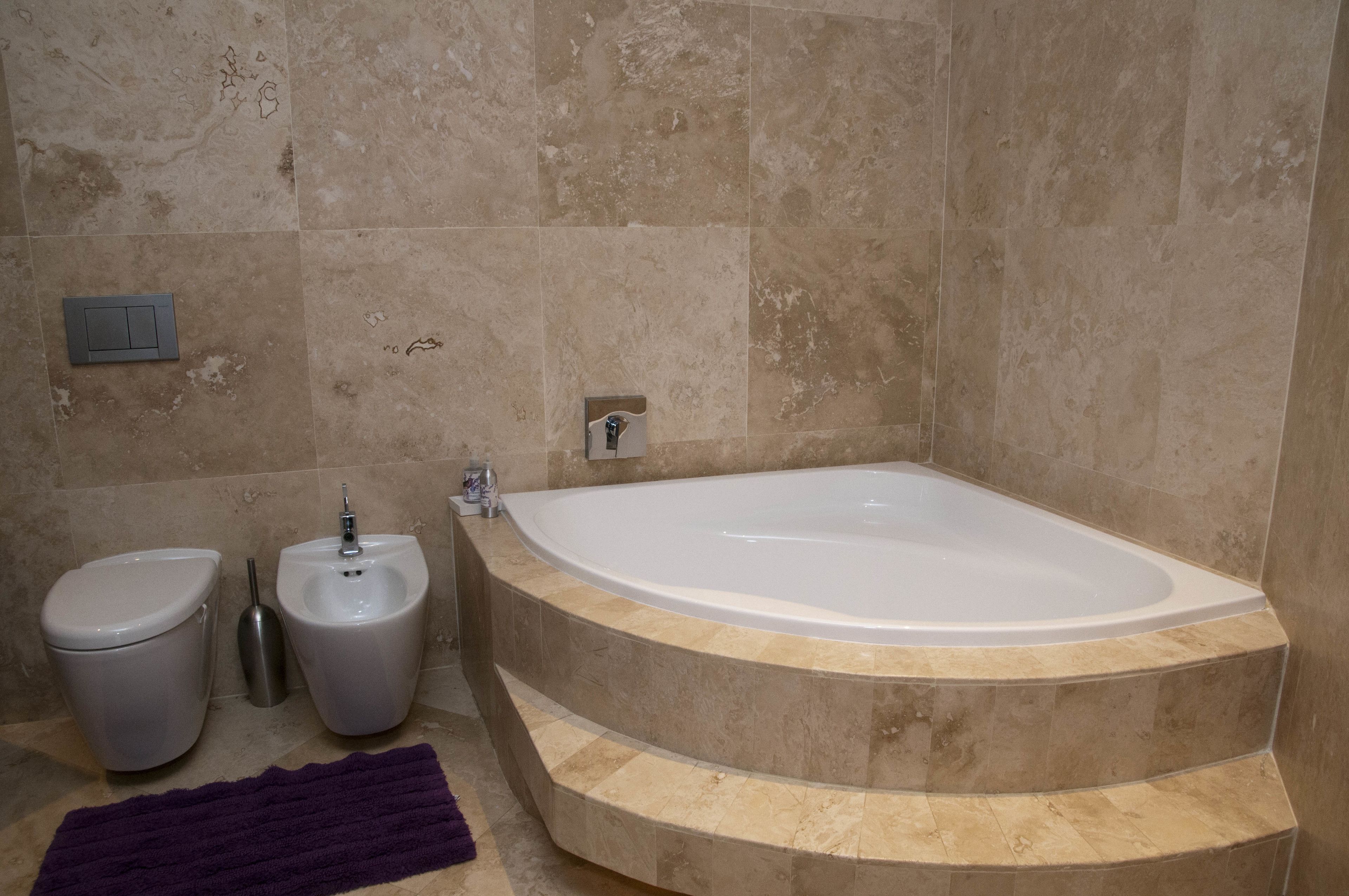 Un baño con una bañera independiente, un inodoro y un bidé.