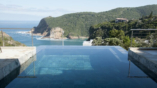 An infinity pool with a view of the ocean and a mountainous landscape. - The Mount Knysna (Knysna)