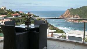 A balcony with wicker furniture overlooking a coastal view. - The Mount Knysna (Knysna)