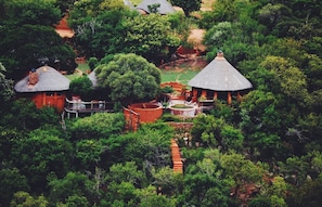Ein Resort mit strohgedeckten Hütten, umgeben von üppiger Vegetation.