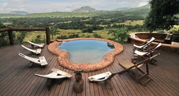 Una piscina al aire libre, sillones reclinables de piscina