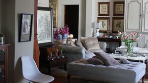 Un soggiorno con divano, poltrone, tavolino e credenza con vetrine.