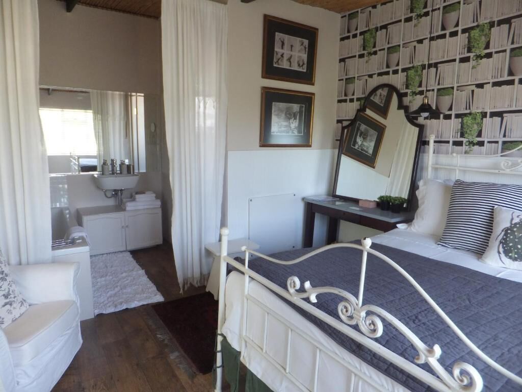 A bedroom with a bed, a bedside table, a mirror, a dresser, and a bookshelf.