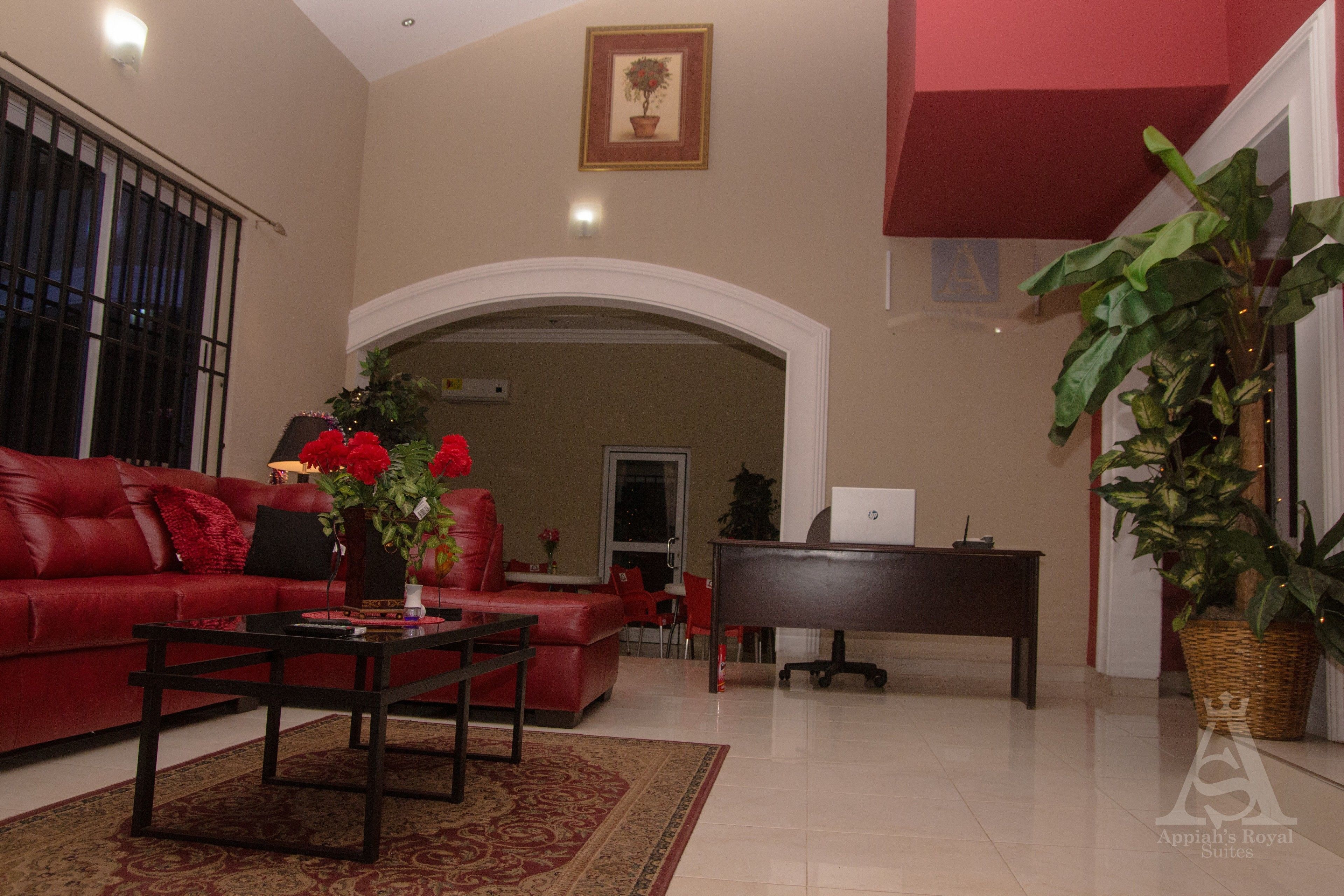 Amplia sala de estar con un sofá rojo, una mesa de centro y un piano.