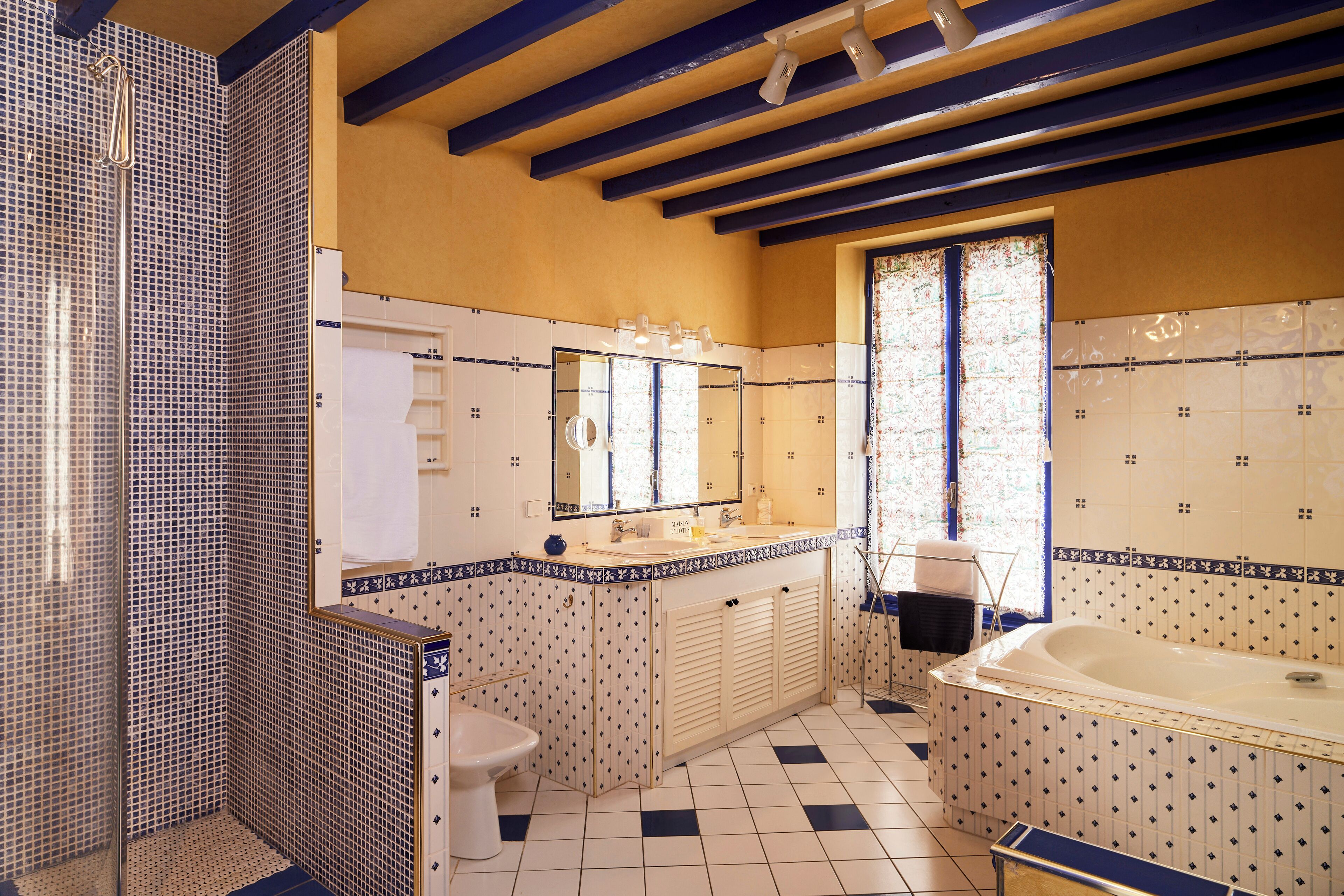 Une salle de bain équipée d’une baignoire, d’un lavabo, d’un miroir et d’un espace douche.