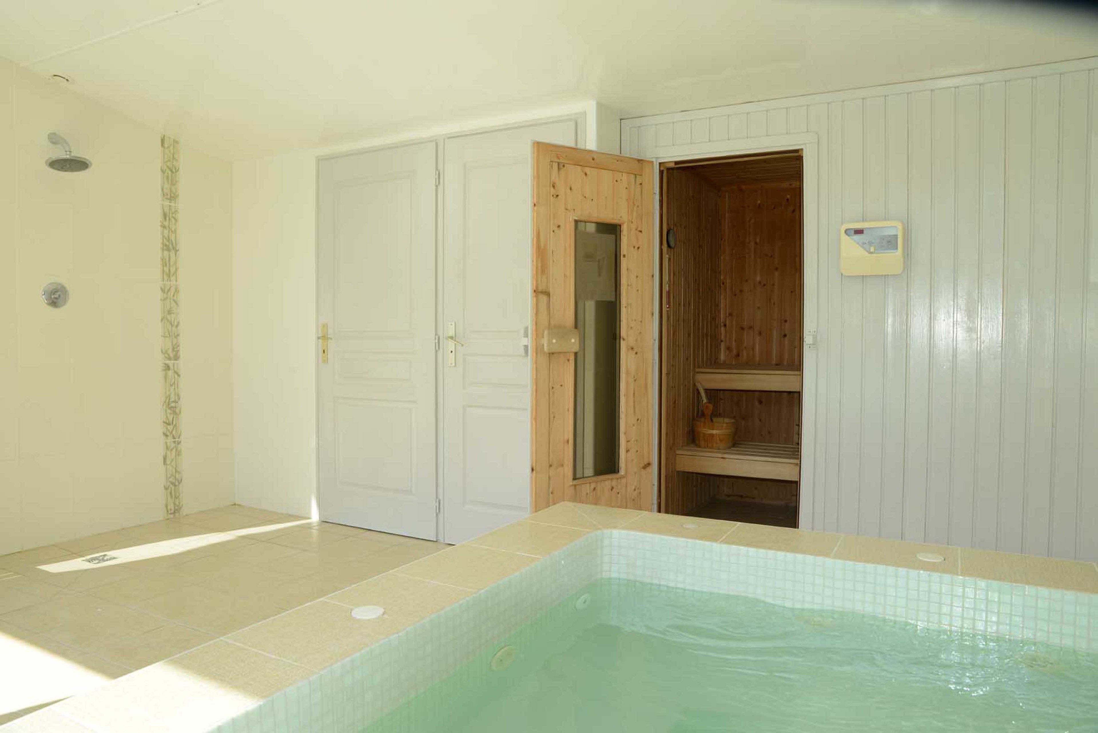 A room with a tiled floor, a wooden door, a small window, and a built-in wooden shelf.
