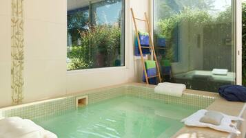 Relax by the serene indoor pool, surrounded by lush greenery and natural light.