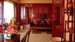 A traditional room with a sofa, wooden furniture, and a decorative vase. - Le Garden (Xi'an)