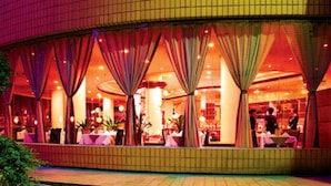 A restaurant with a curved exterior, large windows, and a tiled facade. - Le Garden (Xi'an)