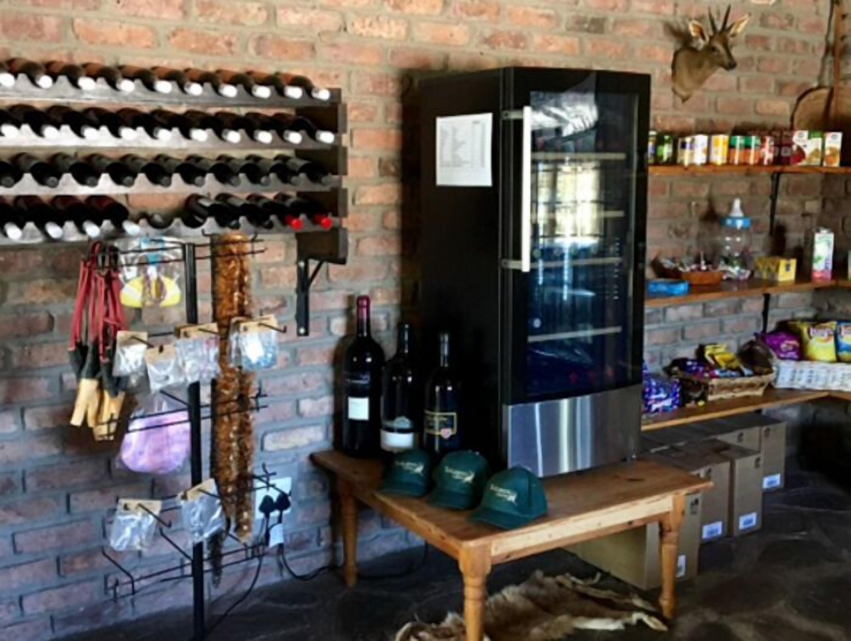 A wine cellar with wine racks, a refrigerator, and various bottles and boxes.