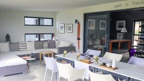 A modern living room with a dining area, featuring a sofa, chairs, a table, and artwork on the walls. - HaesFarm (Stanford)