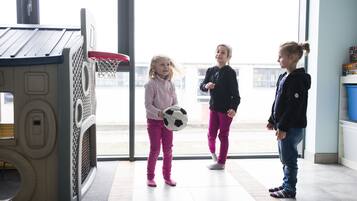 A play area with a small basketball hoop and a soccer ball.