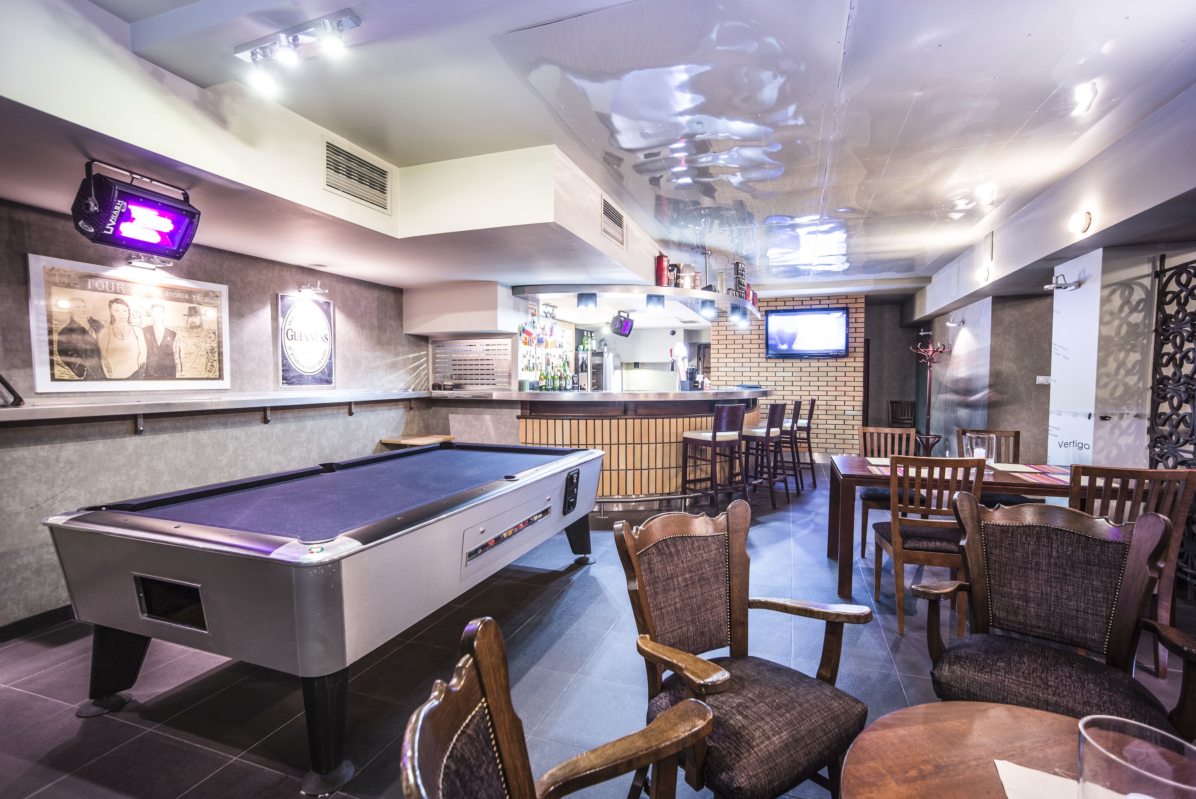A pool table, bar area, and seating arrangement in a lounge setting.