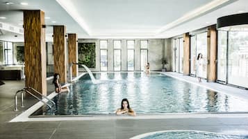 Una piscina techada, sillones reclinables de piscina