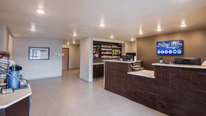 A hotel reception area with a counter, a digital screen displaying social media information, and a beverage kiosk. - My Place Hotel-Salt Lake City/West Jordan, UT (West Jordan)