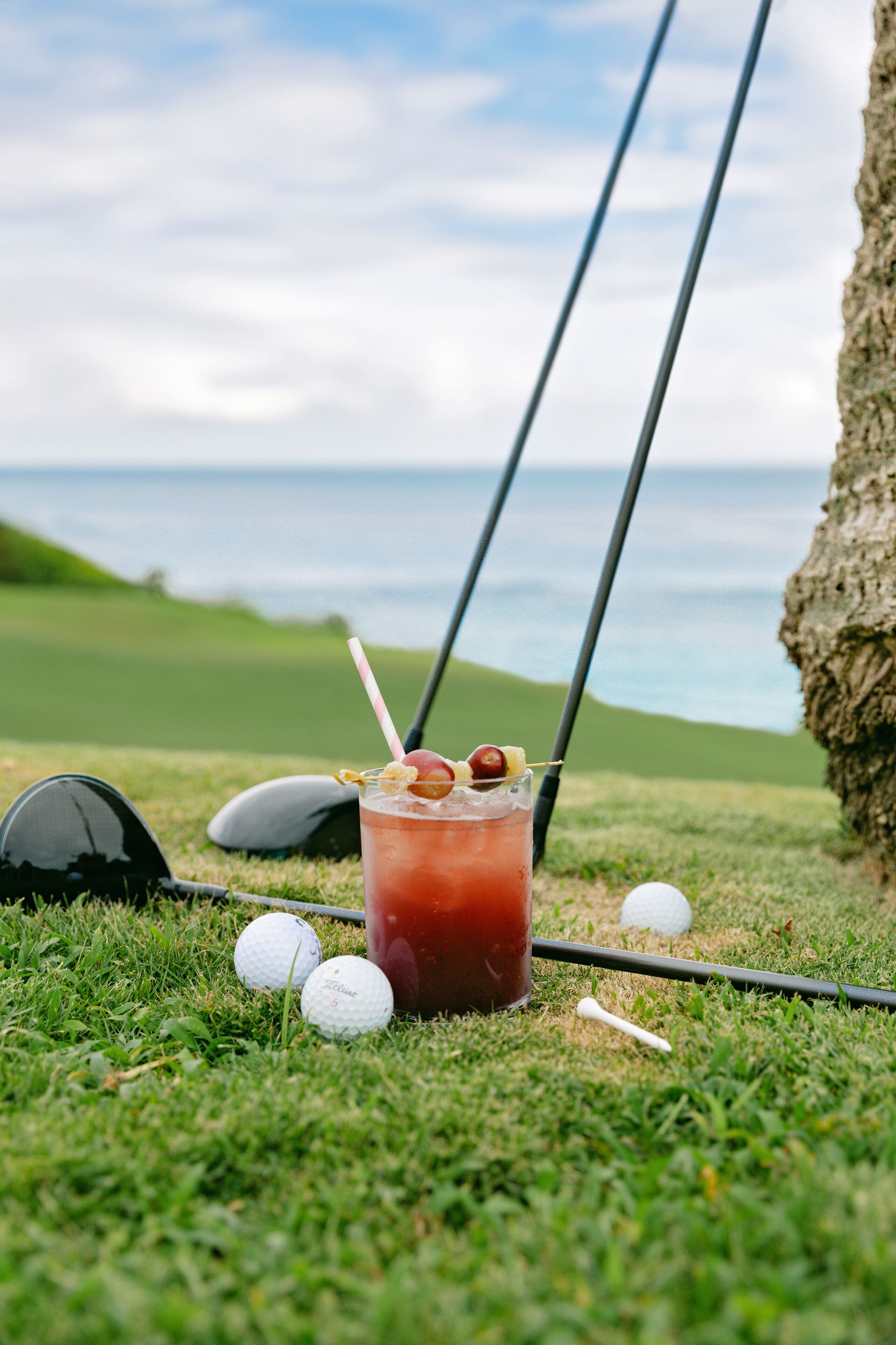 Un campo de golf con bebidas, pelotas y equipo sobre el césped.