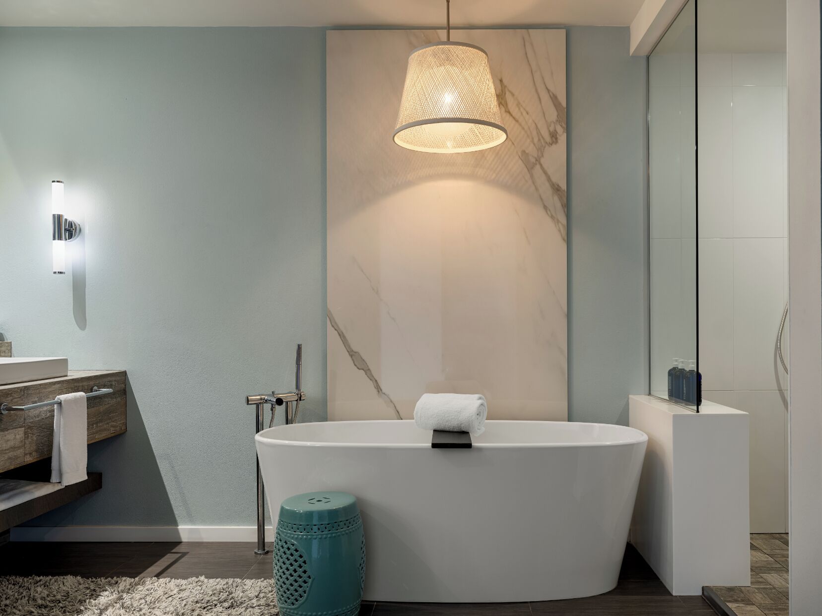 Ein modernes Badezimmer mit einer freistehenden Badewanne, einem Handtuchhalter, einer Toilette und einem Spiegel.