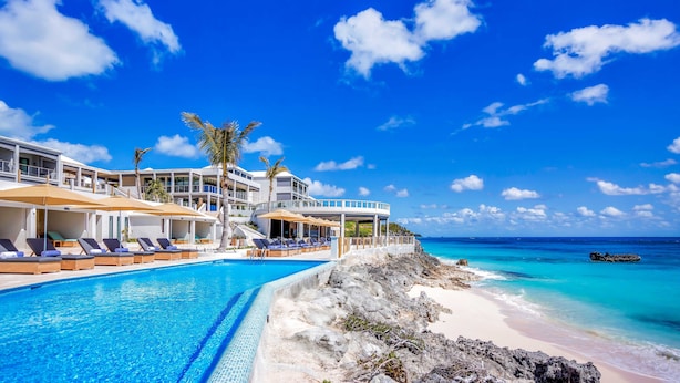 Un resort con piscina, playa y vista al océano.