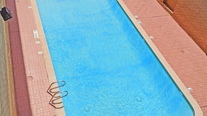 A swimming pool with a tiled edge and a metal ladder. - Motel 6 Houston, TX – Hobby Airport (Houston)