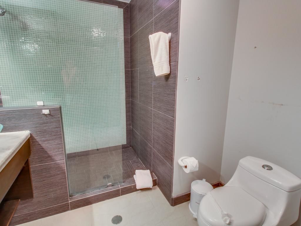 A bathroom with a shower, toilet, and sink.