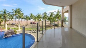Ett modernt hotell med pool och utsikt över stranden.