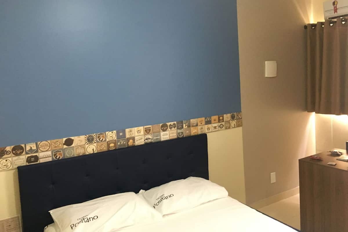 A hotel room with a blue accent wall, a dark headboard, and a decorative border.