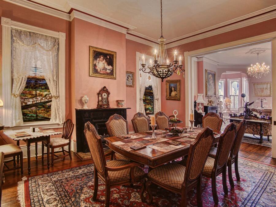 A formal dining room with a large wooden table, ornate chairs, and a chandelier.